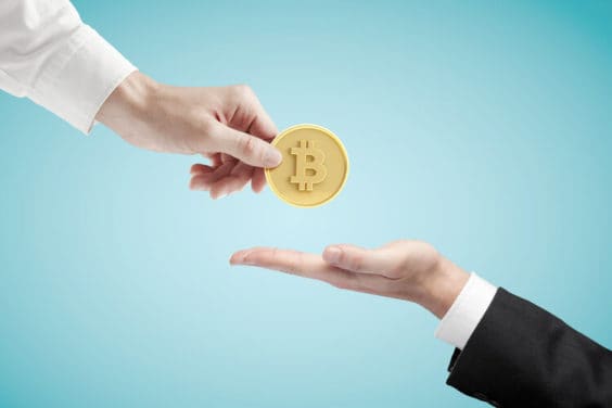 hand giving bitcoin on a blue background